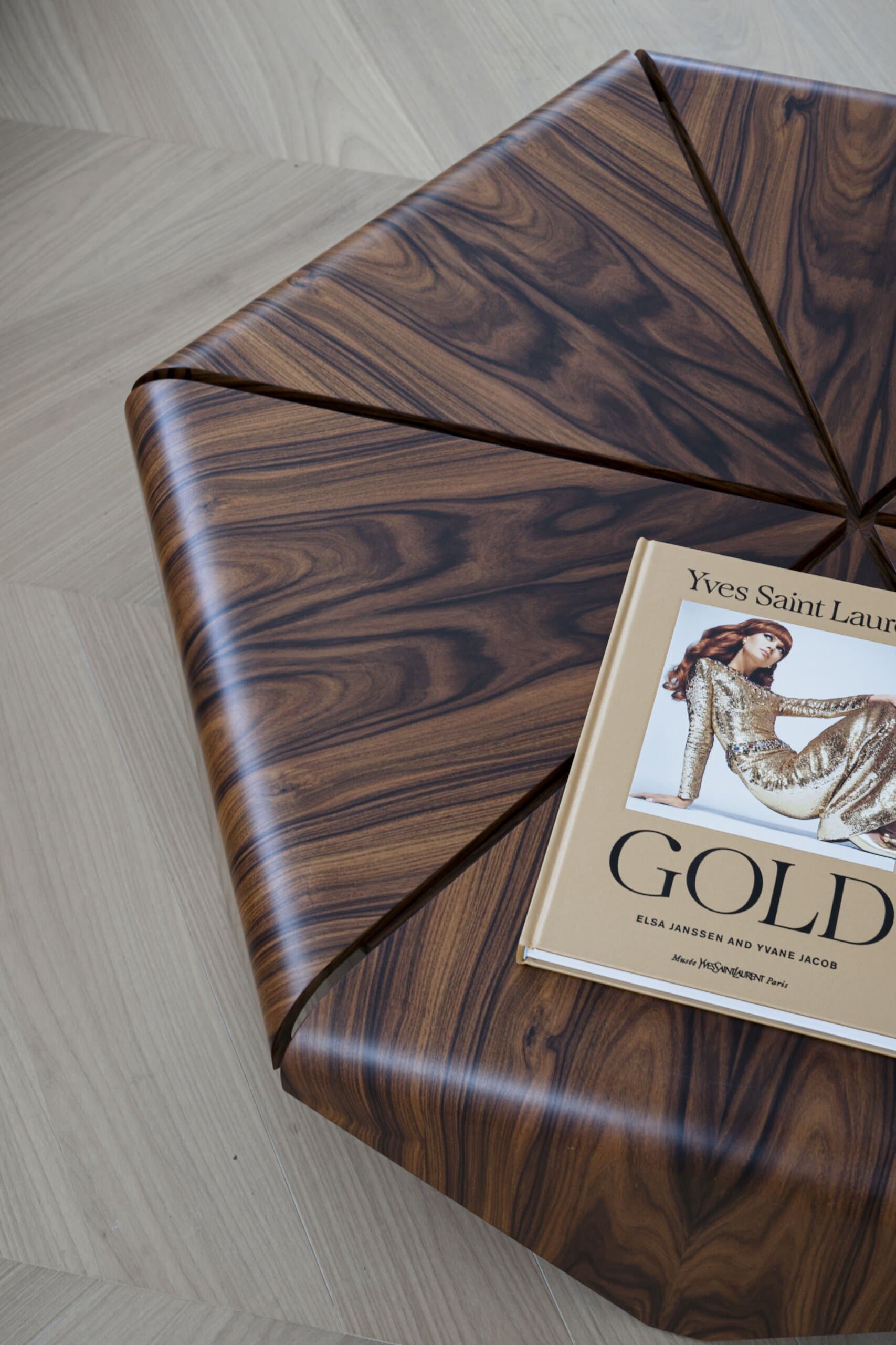 Detail: the faceted rosewood coffee table from above, an Yves Saint Laurent book on its top.