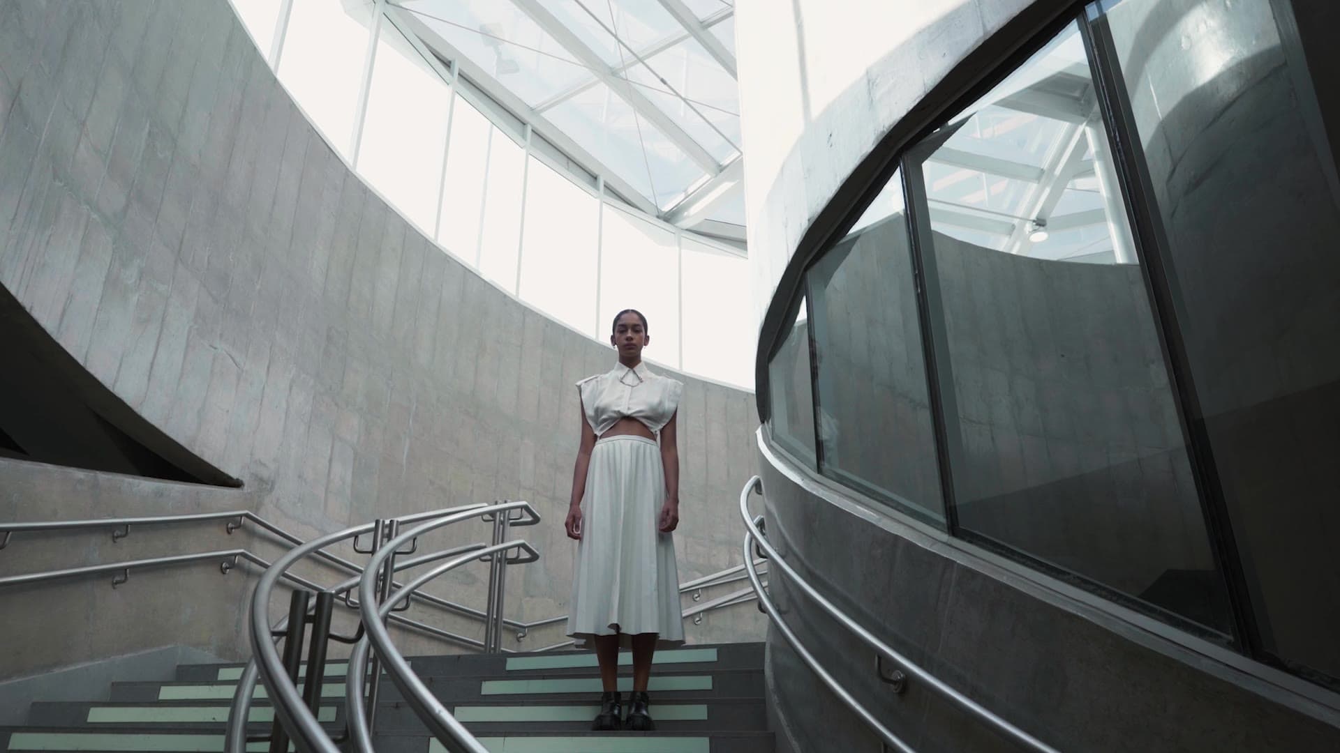 Laboissiere — the film: two women in white move together in front of a steel-framed glass wall.