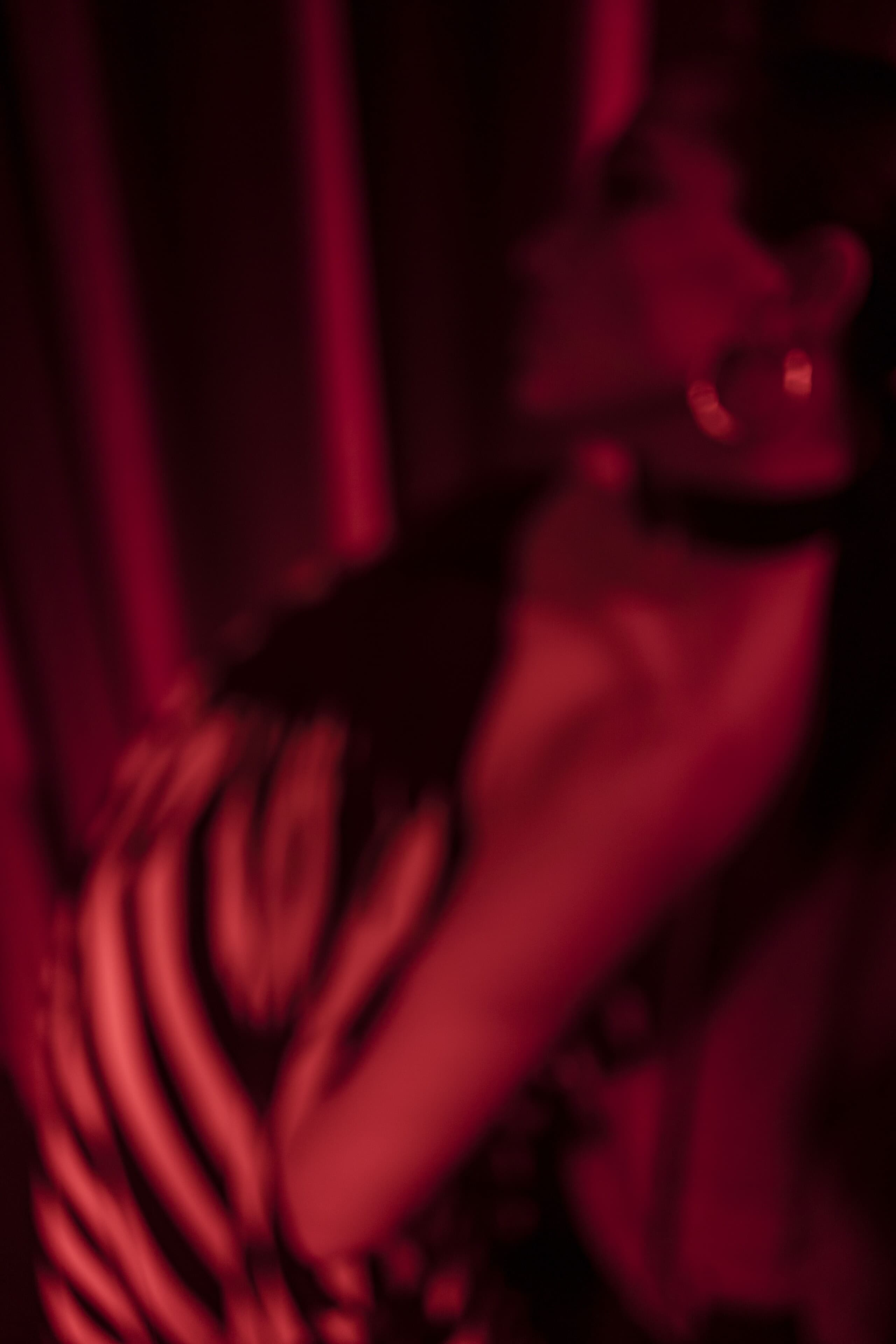 A figure dissolving into red light and motion blur.