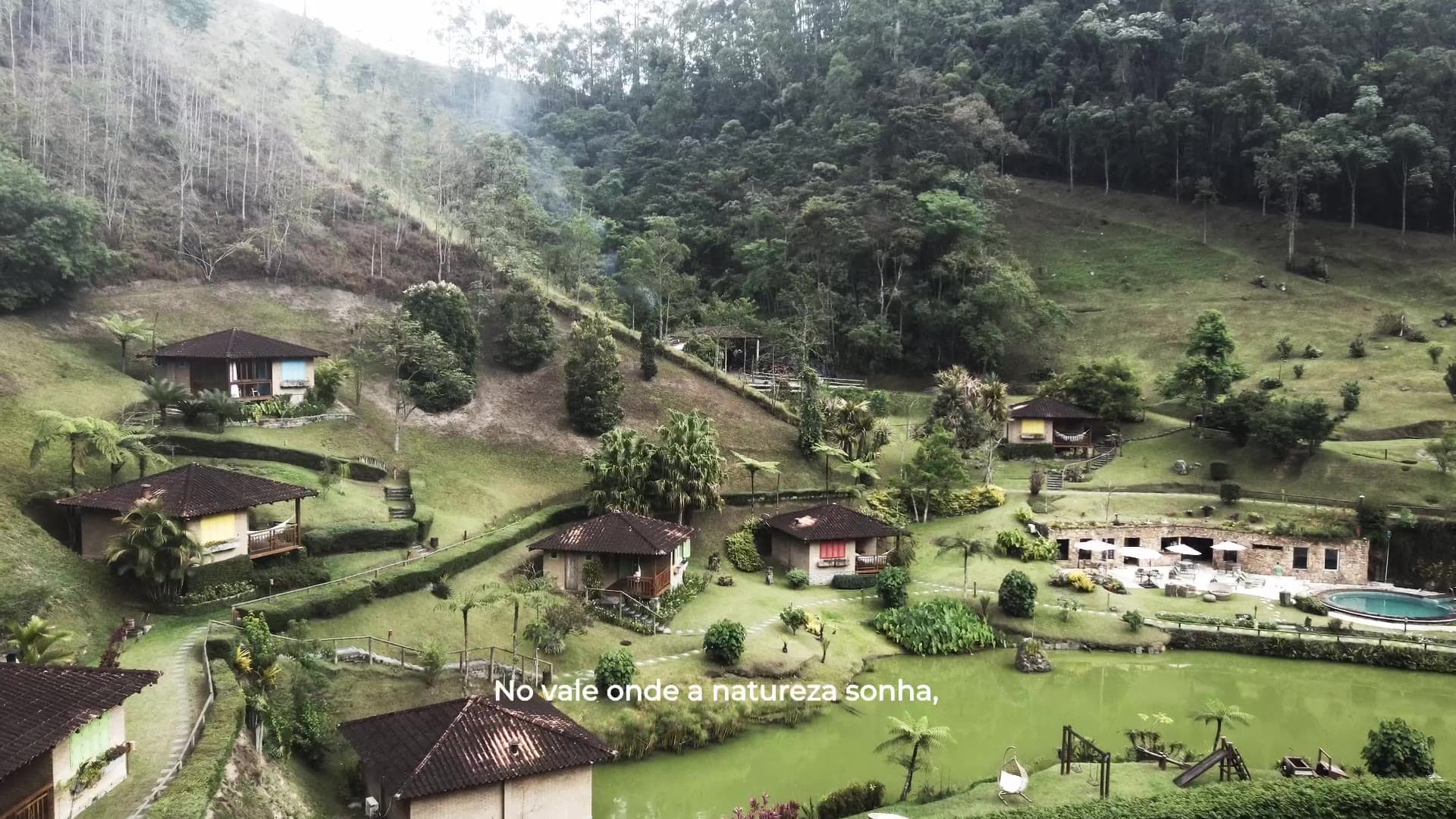Parador — o filme: chalés espalhados por uma encosta verde, vales de montanha na neblina.