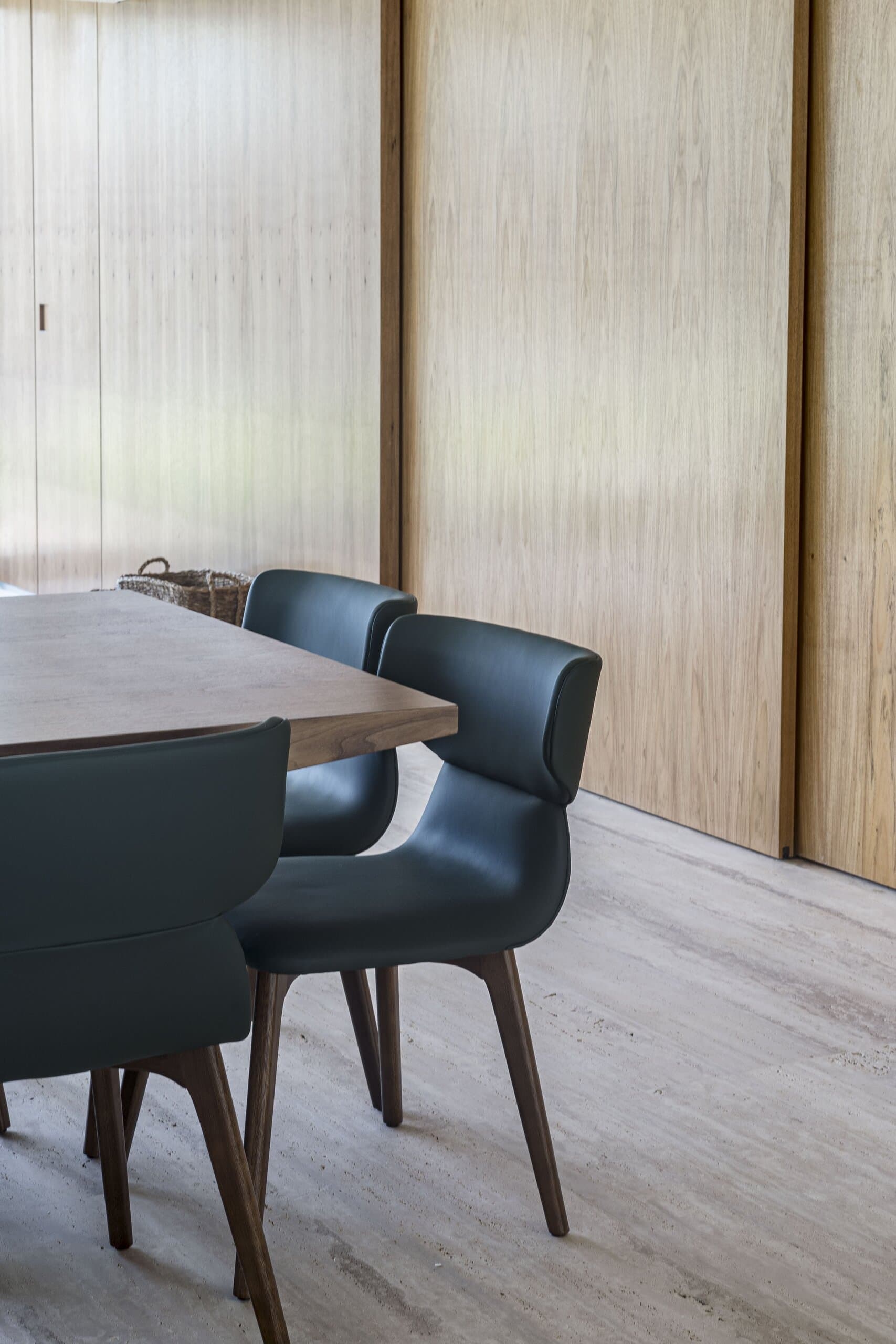 Blue upholstered chairs at a timber table beside sliding timber panels.