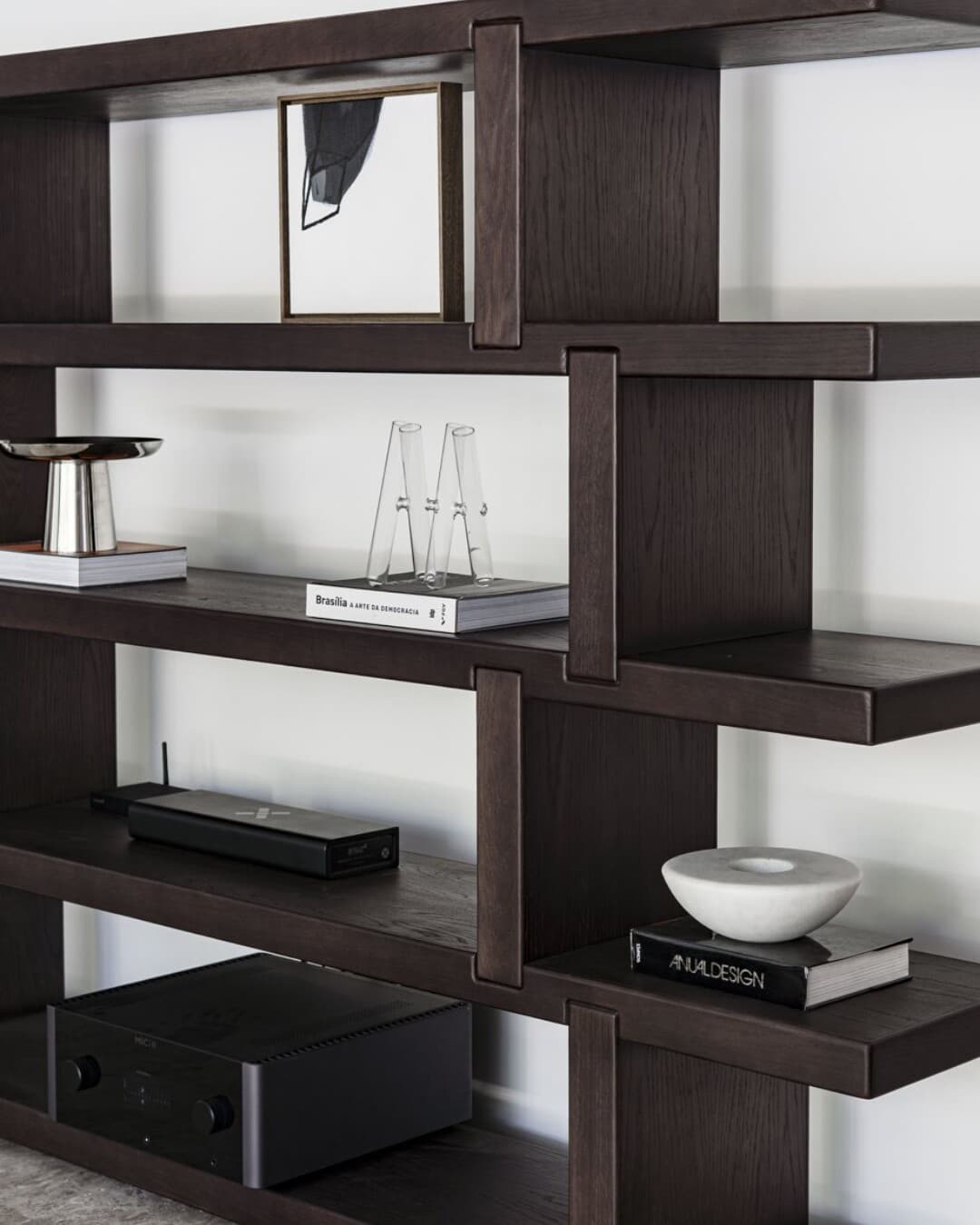 Carousel frame: the dark timber shelf styled in a room with books, objects and a turntable.